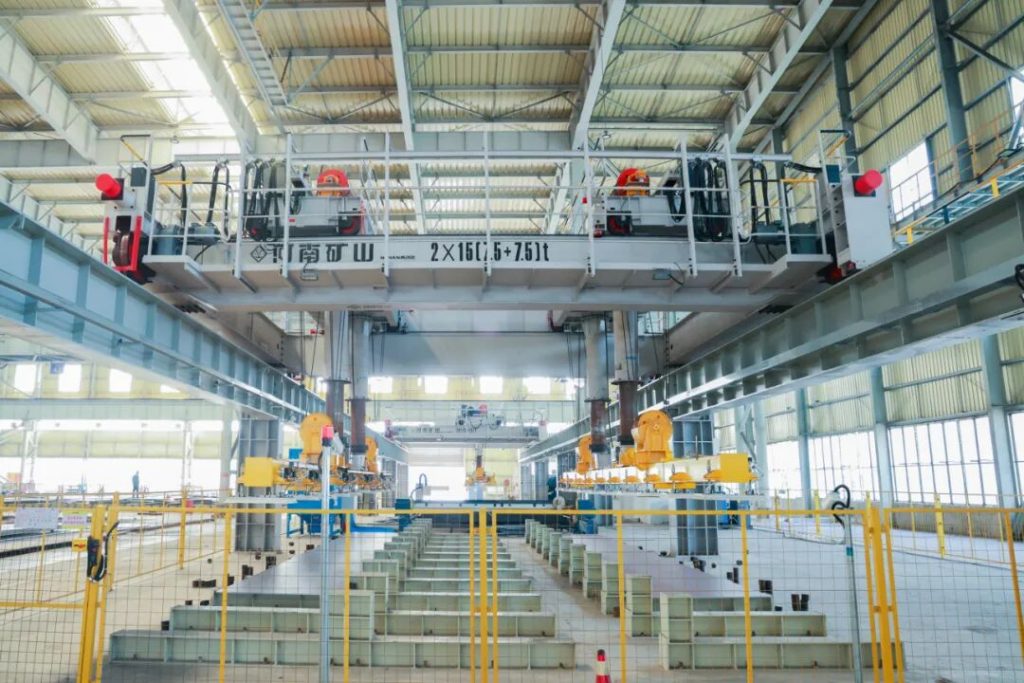 Guarded automated steel-plate handling line inside the workshop