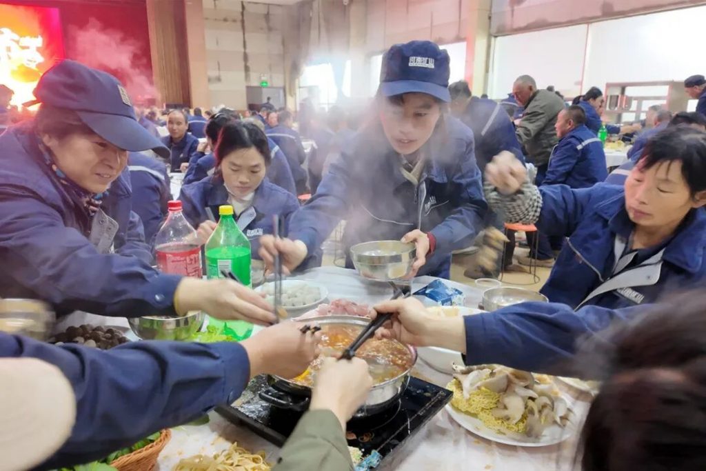 Workshop employees preparing food around a hotpot table