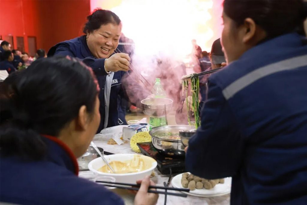 Employees serving food from a steaming hotpot