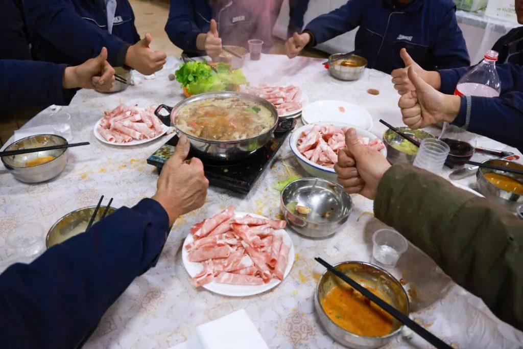 Shared dishes and hotpot ingredients on a round table