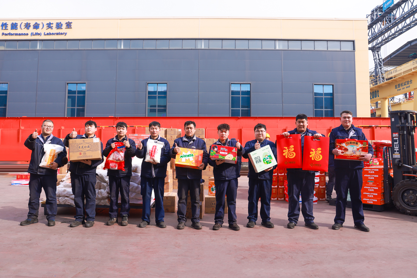 Employees holding New Year gifts outside the testing laboratory at Henan Mine Crane before the Lunar New Year