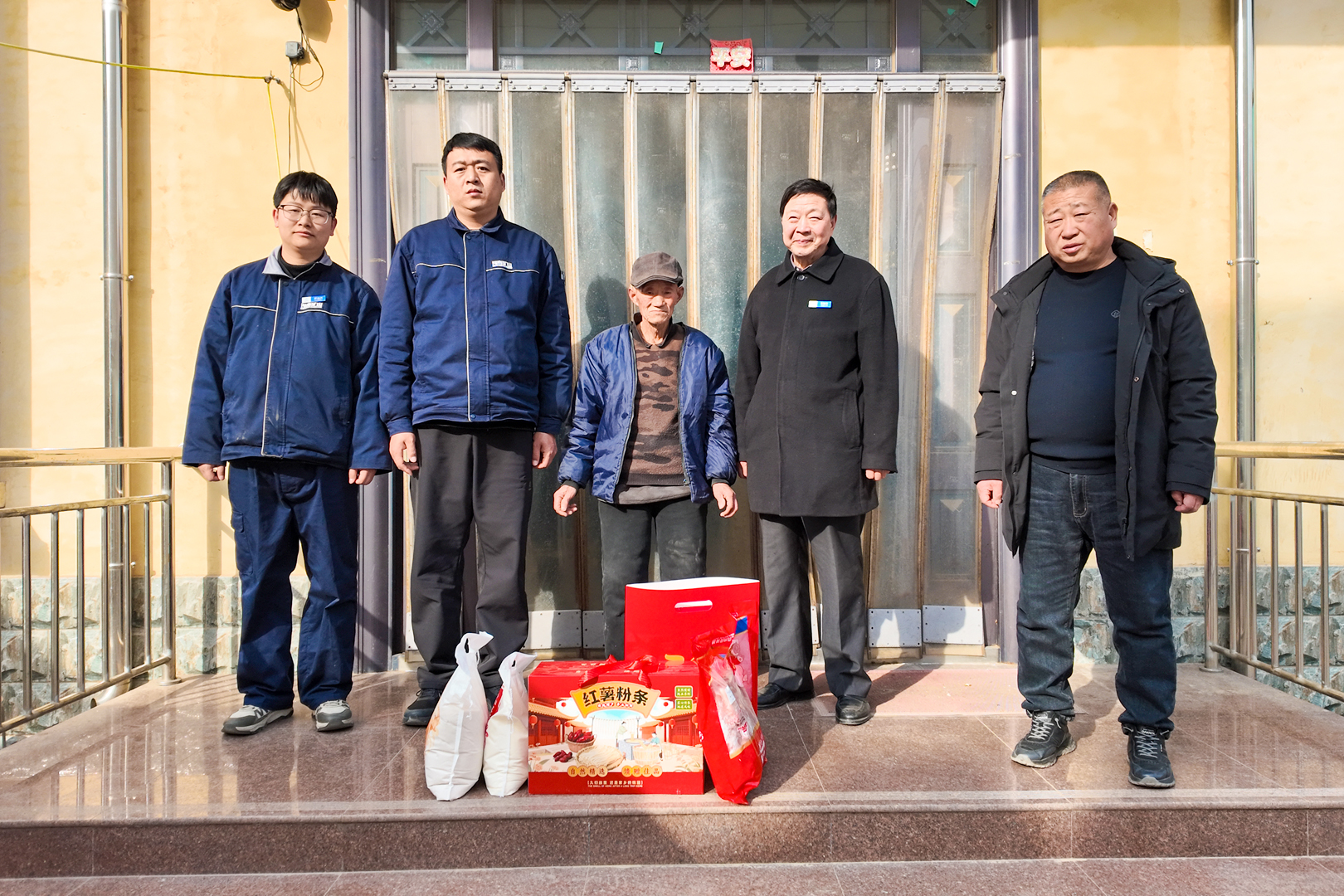 Outreach team visiting residents at a doorway during Henan Mine Crane’s New Year outreach