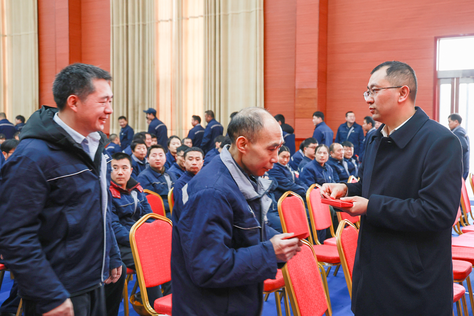 Employee receiving a holiday benefit envelope at Henan Mine Crane before the Lunar New Year