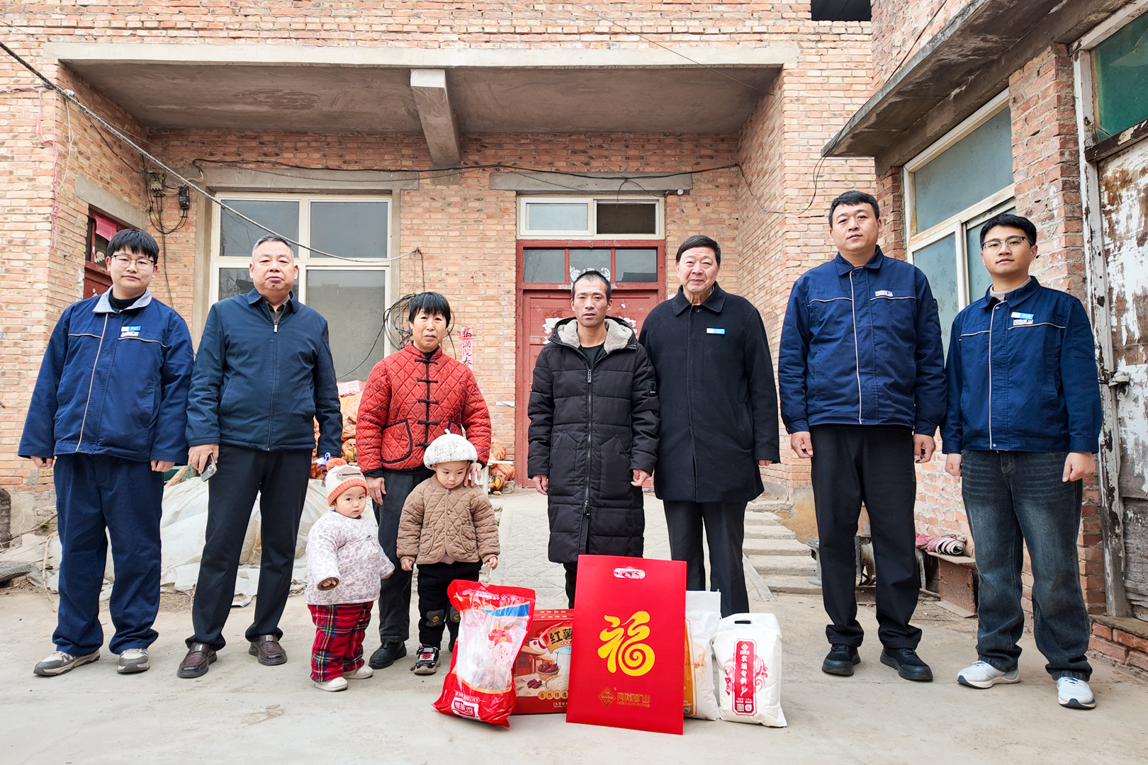 Residents and company representatives with New Year gift packages during Henan Mine Crane’s New Year outreach