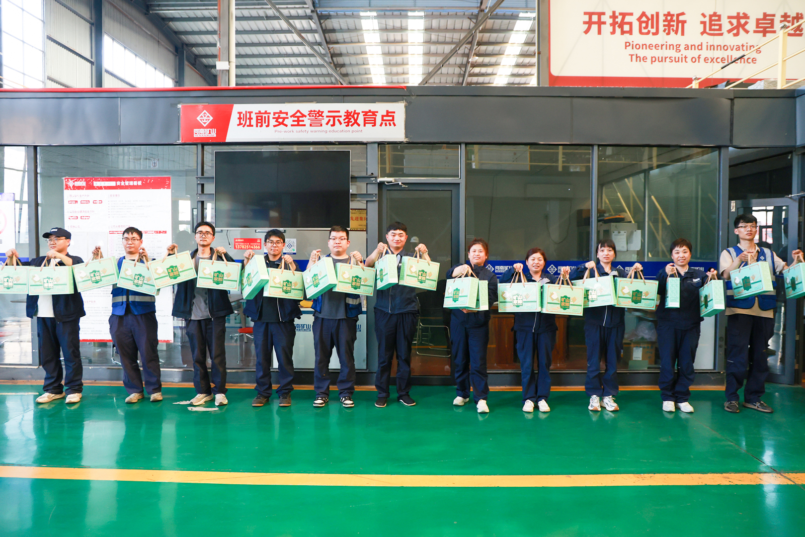 Employees gathered outside a manufacturing workshop with gifts