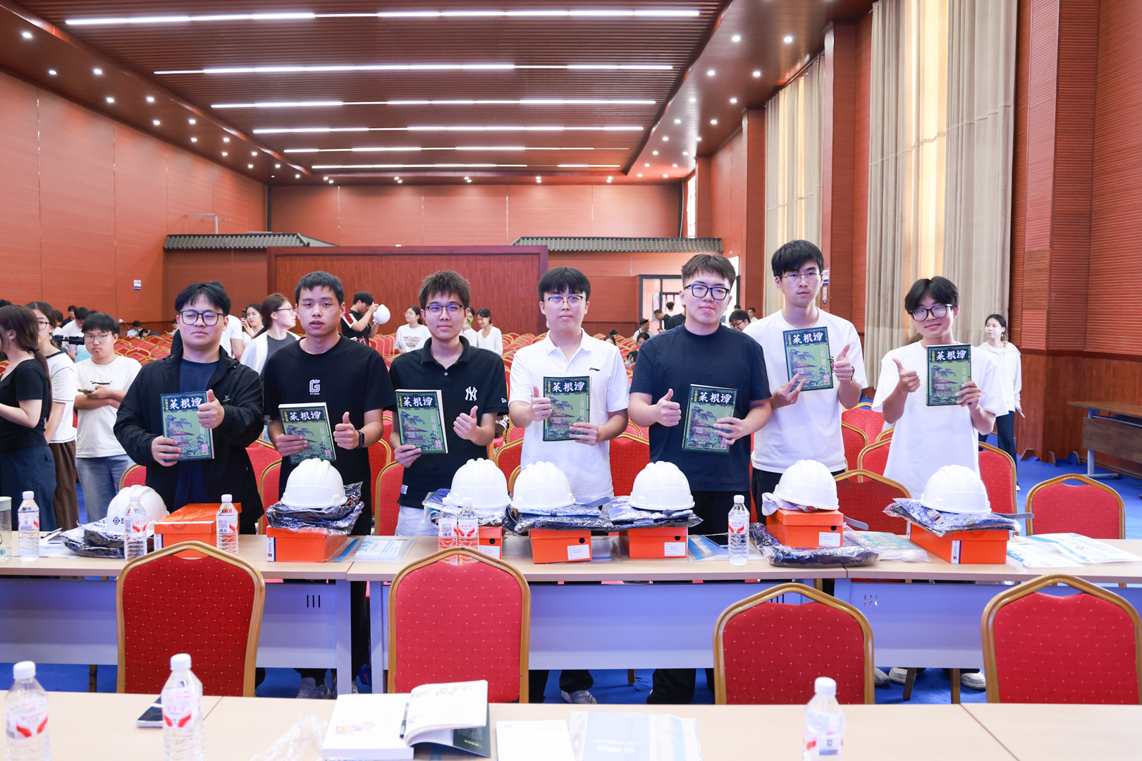Students displaying books received at the internship launch