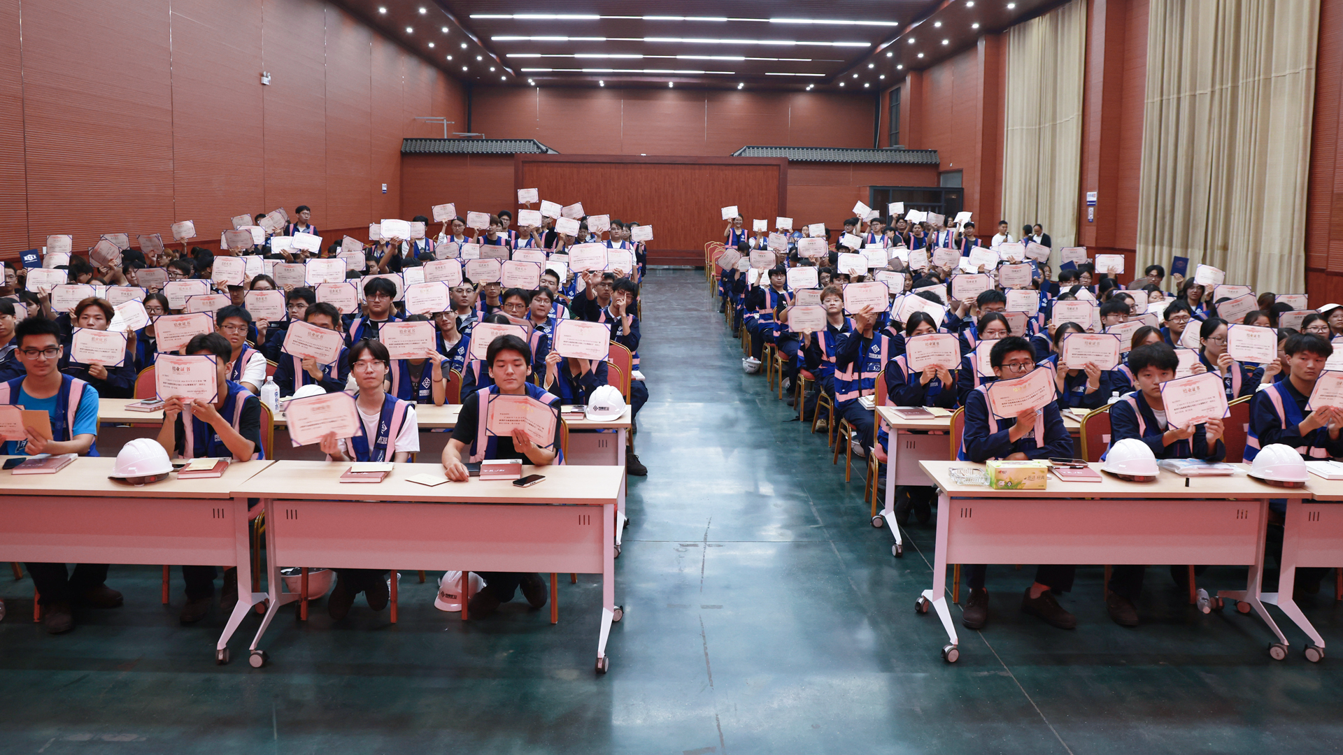 Participants displaying completion certificates in the hall
