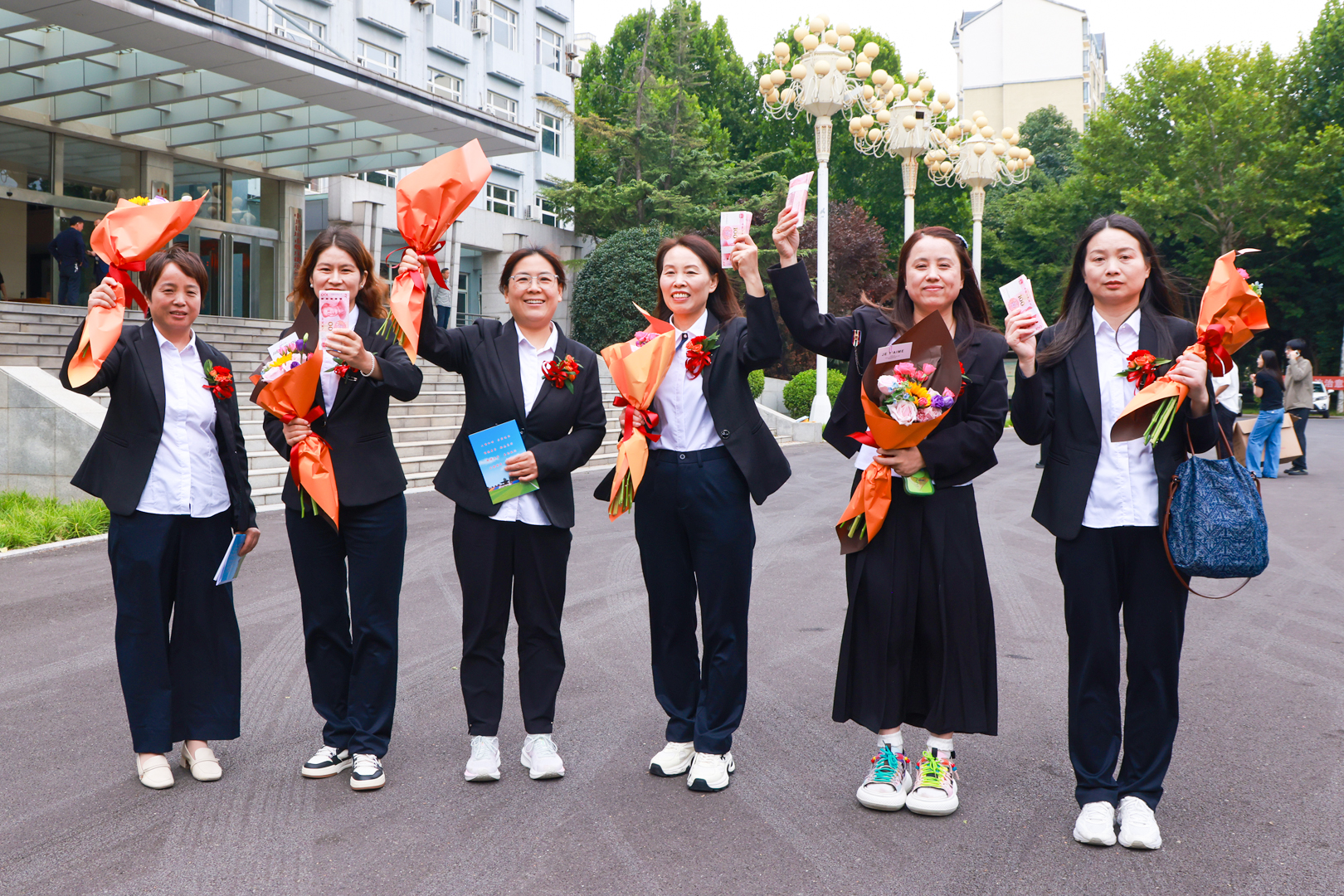 Teachers holding flowers outside the meeting venue Teachers holding flowers outside the meeting venue