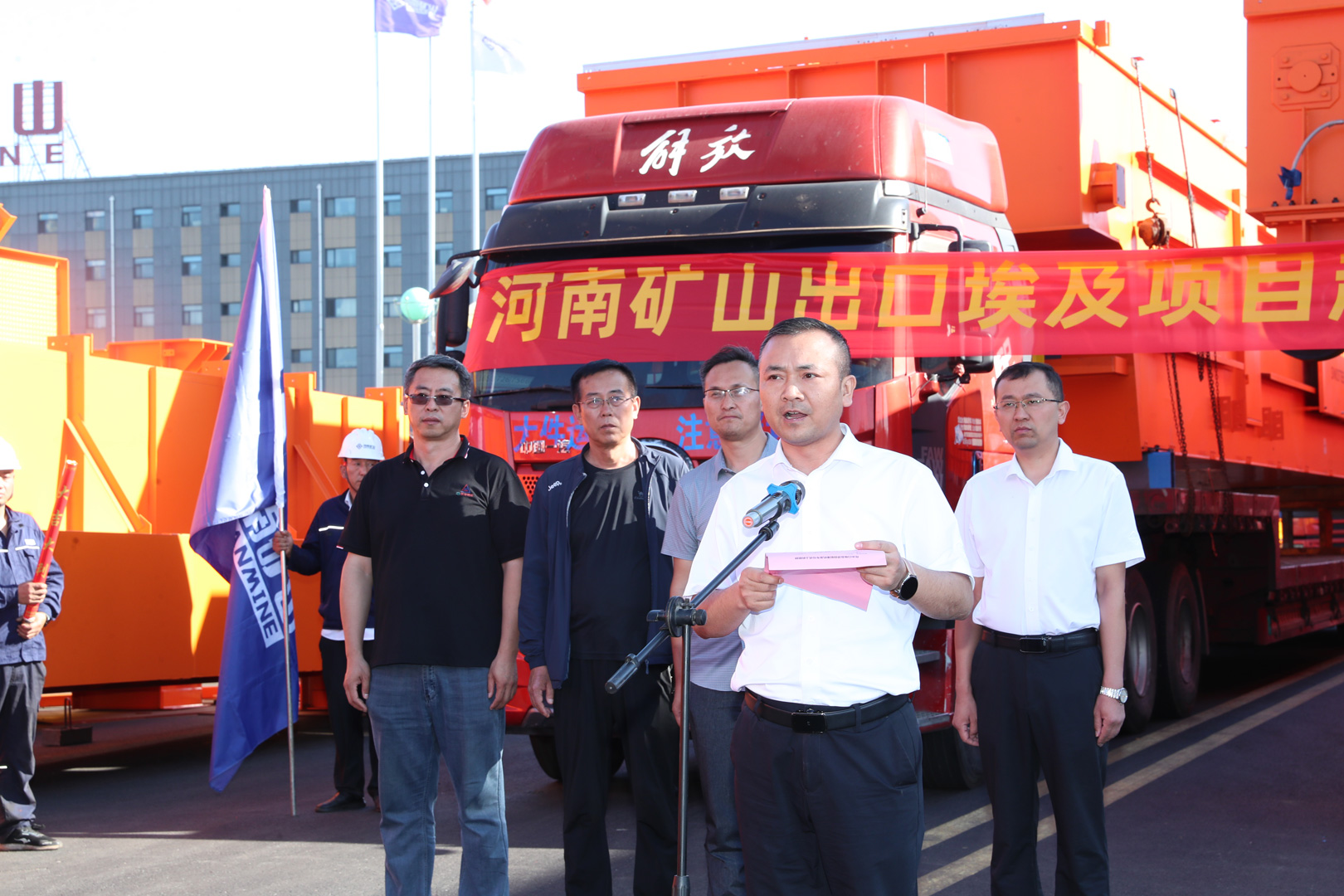 Representatives beside a loaded crane shipment truck