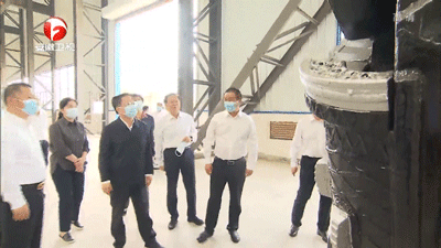 Visitors inspecting heavy manufacturing equipment