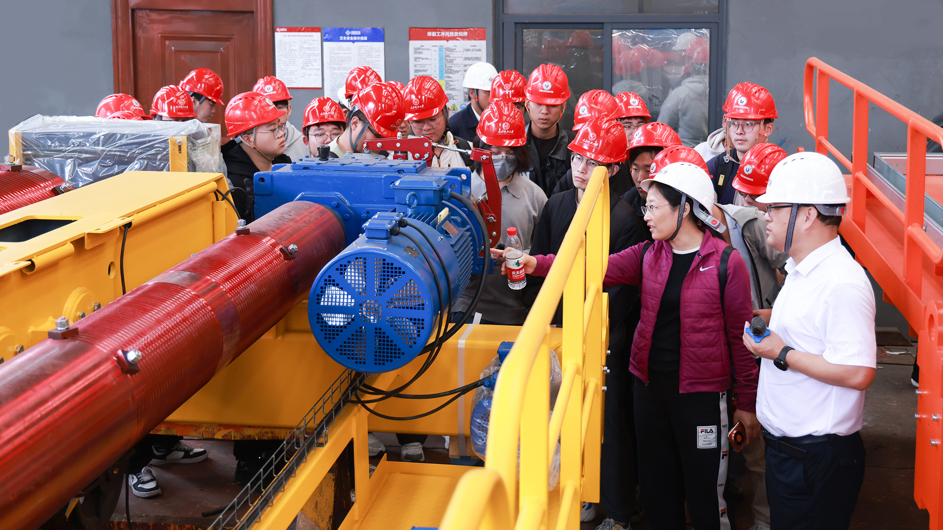 Visitors examining crane machinery in a Henan Mine Crane production workshop