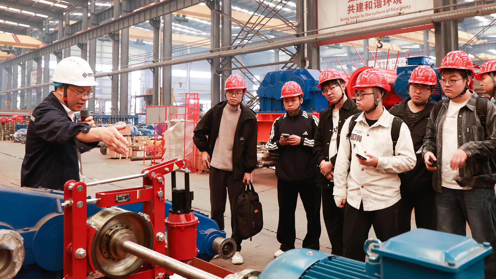Henan Mine Crane guide explaining production equipment to university visitors
